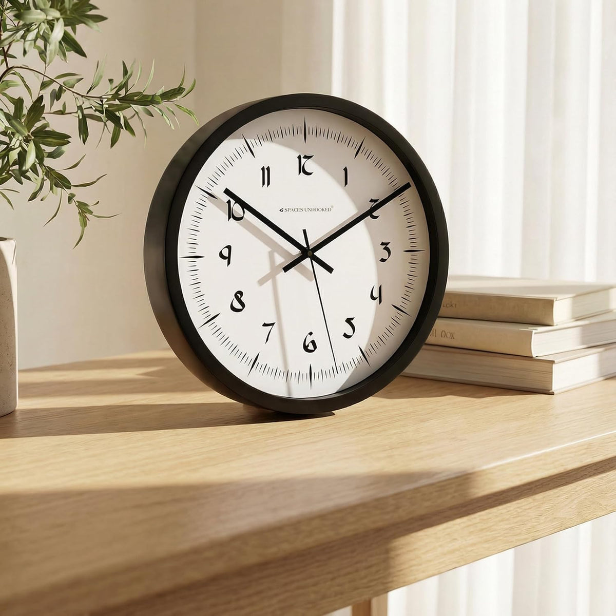 Round wall clock on a wooden shelf with books and a plant in the background