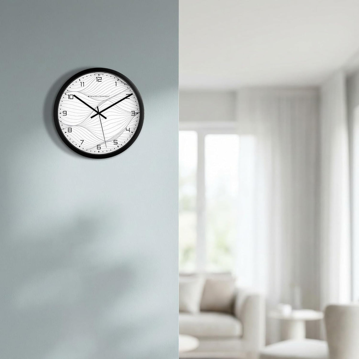 Wall clock on a gray wall with a blurred living room in the background