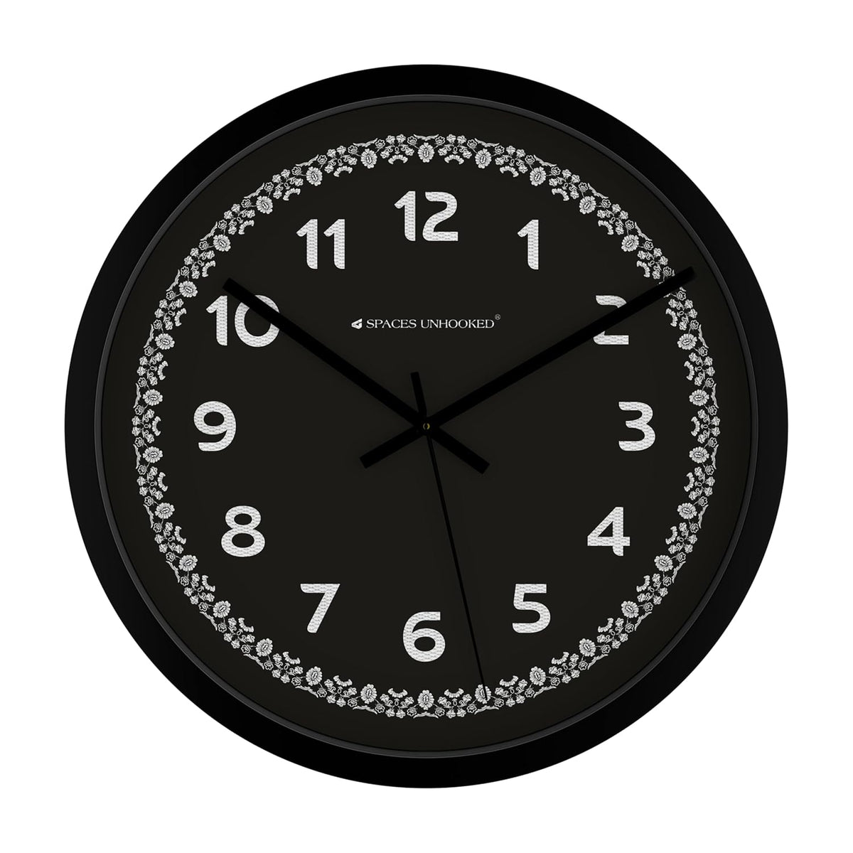 Black wall clock with decorative floral border and brand name on a white background