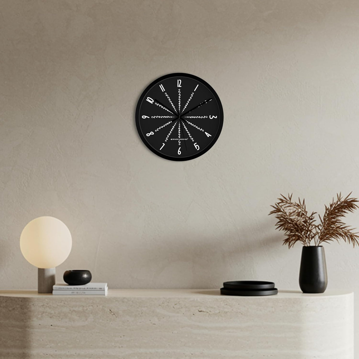 Black wall clock on a beige wall with minimal decor
