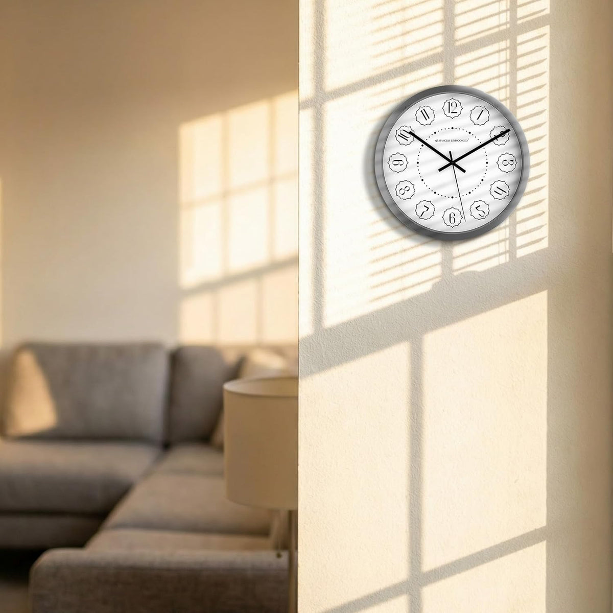 Wall clock on a wall with a living room in the background