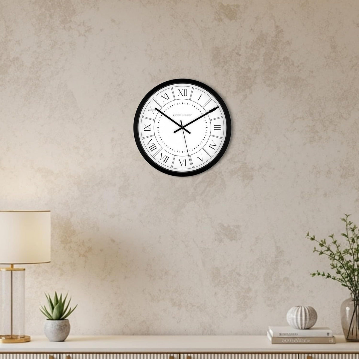 Wall clock on a textured wall with a lamp and decor items below.
