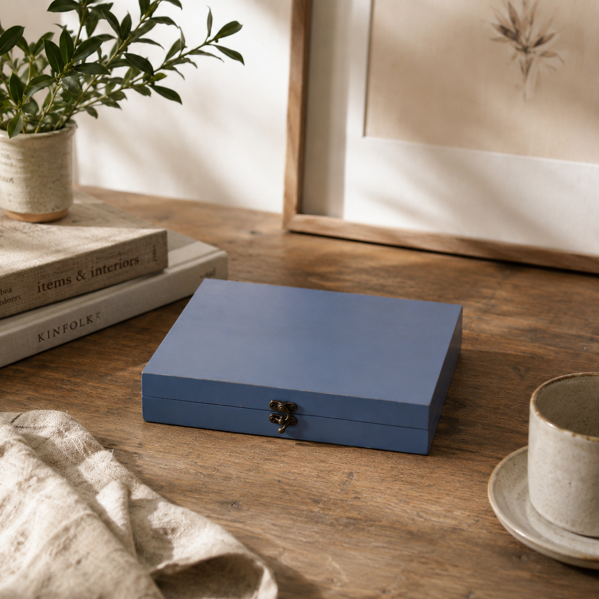 Blue box on a wooden surface with a plant and books in the background