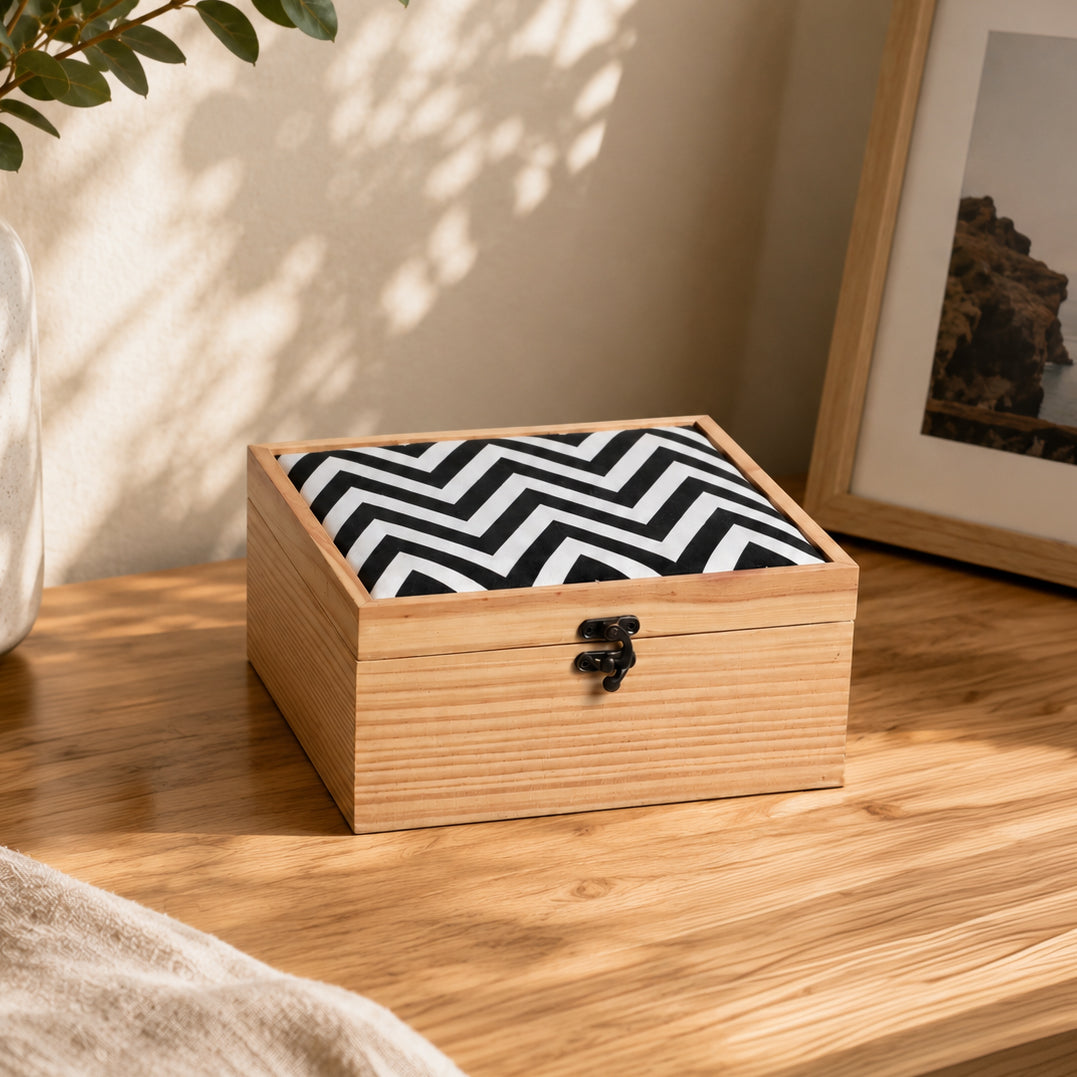 Wooden box with a black and white zigzag pattern on a wooden surface