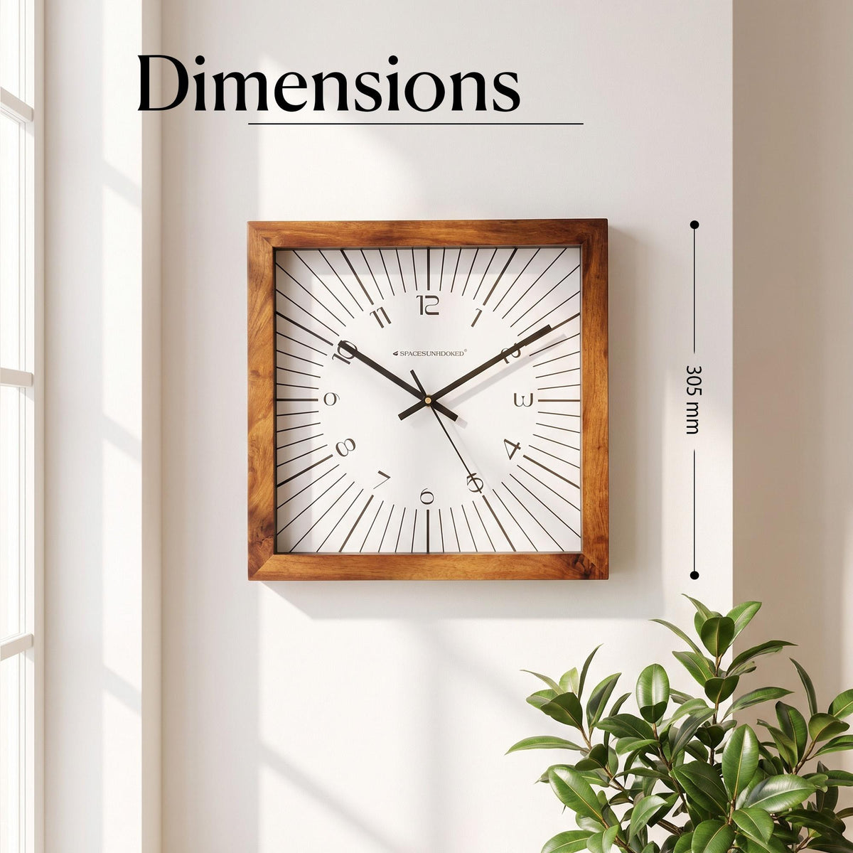 Graphic sunburst wall clock in a home office with black frames, light wood and a plant