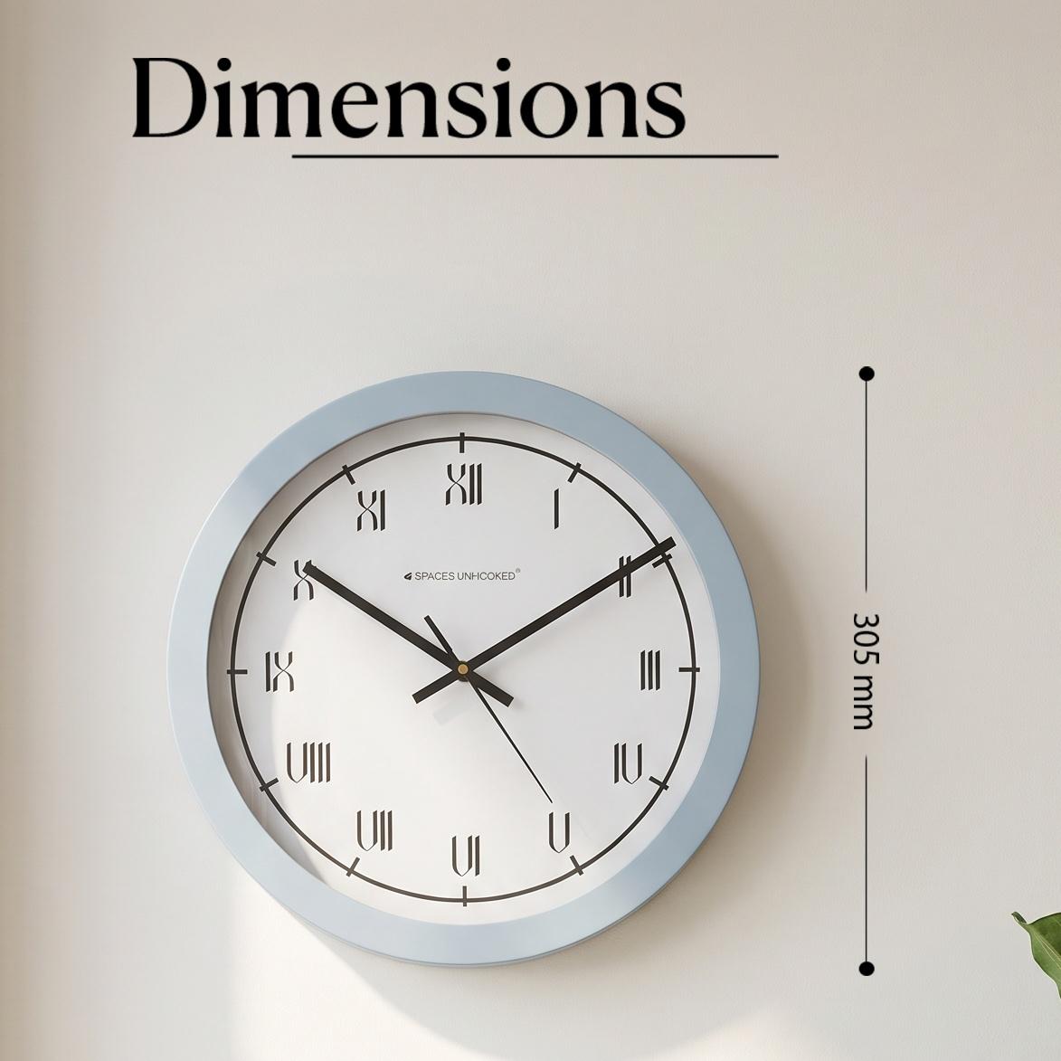 Pale blue Roman numeral wall clock in a bedroom with white bedding, linen and brass accents