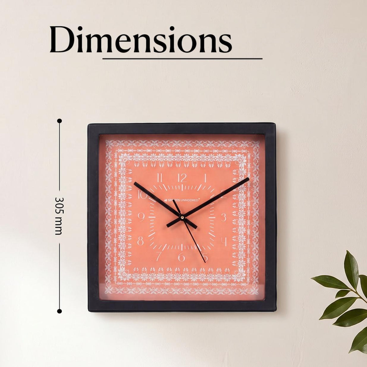 Close-up of white floral lace border and slim numerals on a coral clock dial