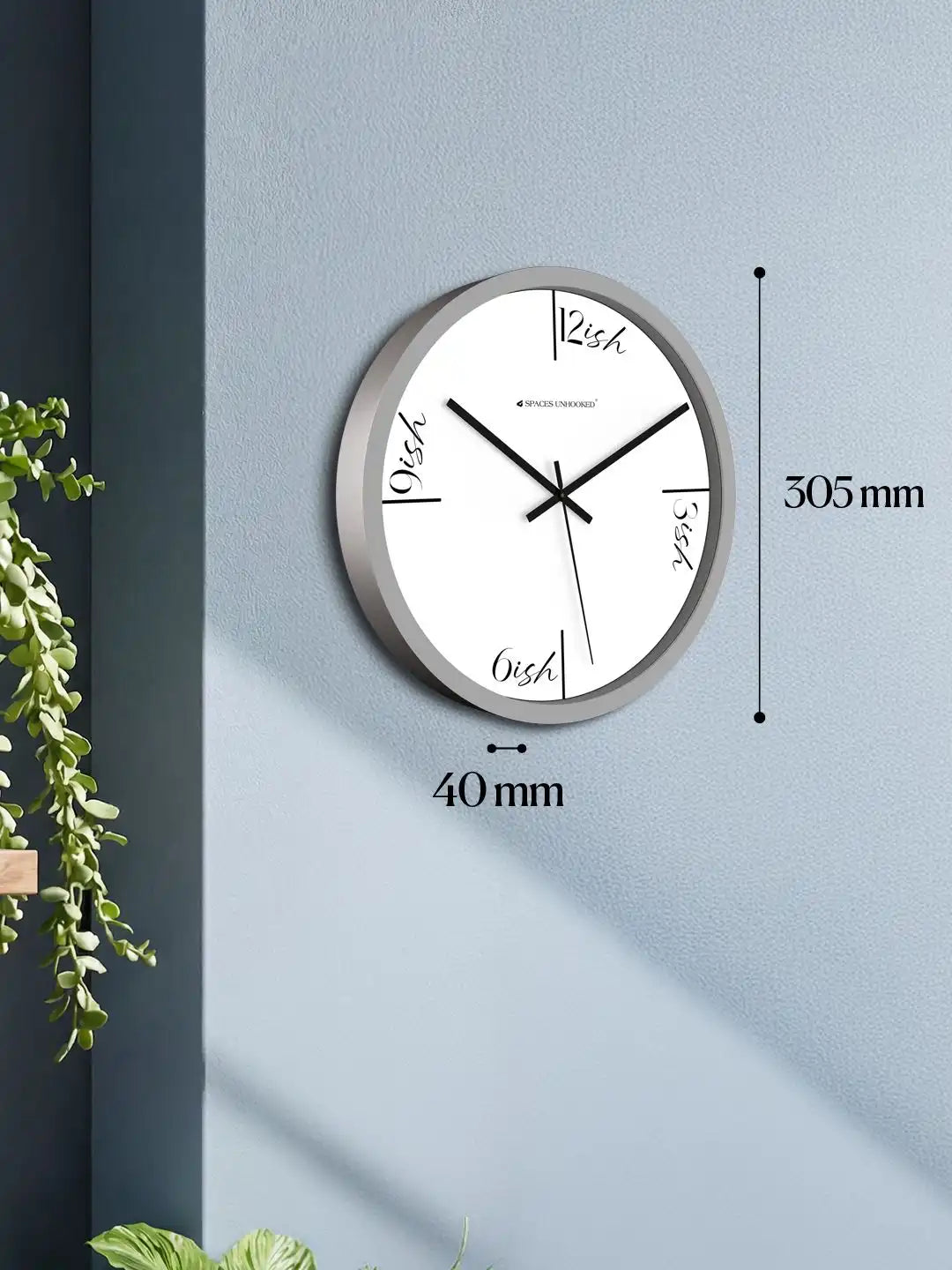 Grey wall clock mounted on a blue-grey wall with dimension labels showing 40mm depth and 305mm diameter