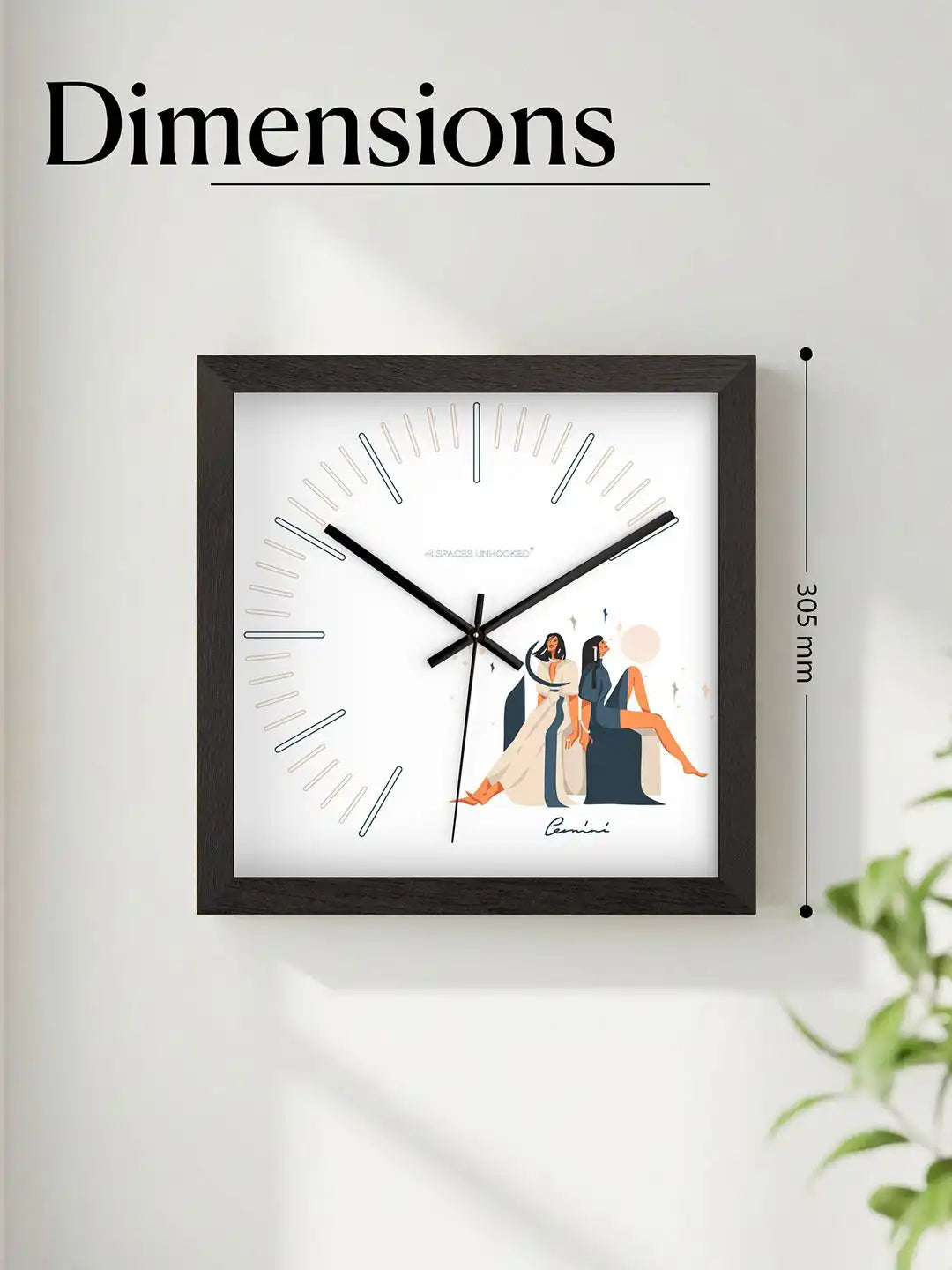 Gemini zodiac wall clock mounted on a neutral wall above a tabletop with greenery and decorative accents, creating a modern bohemian interior look.