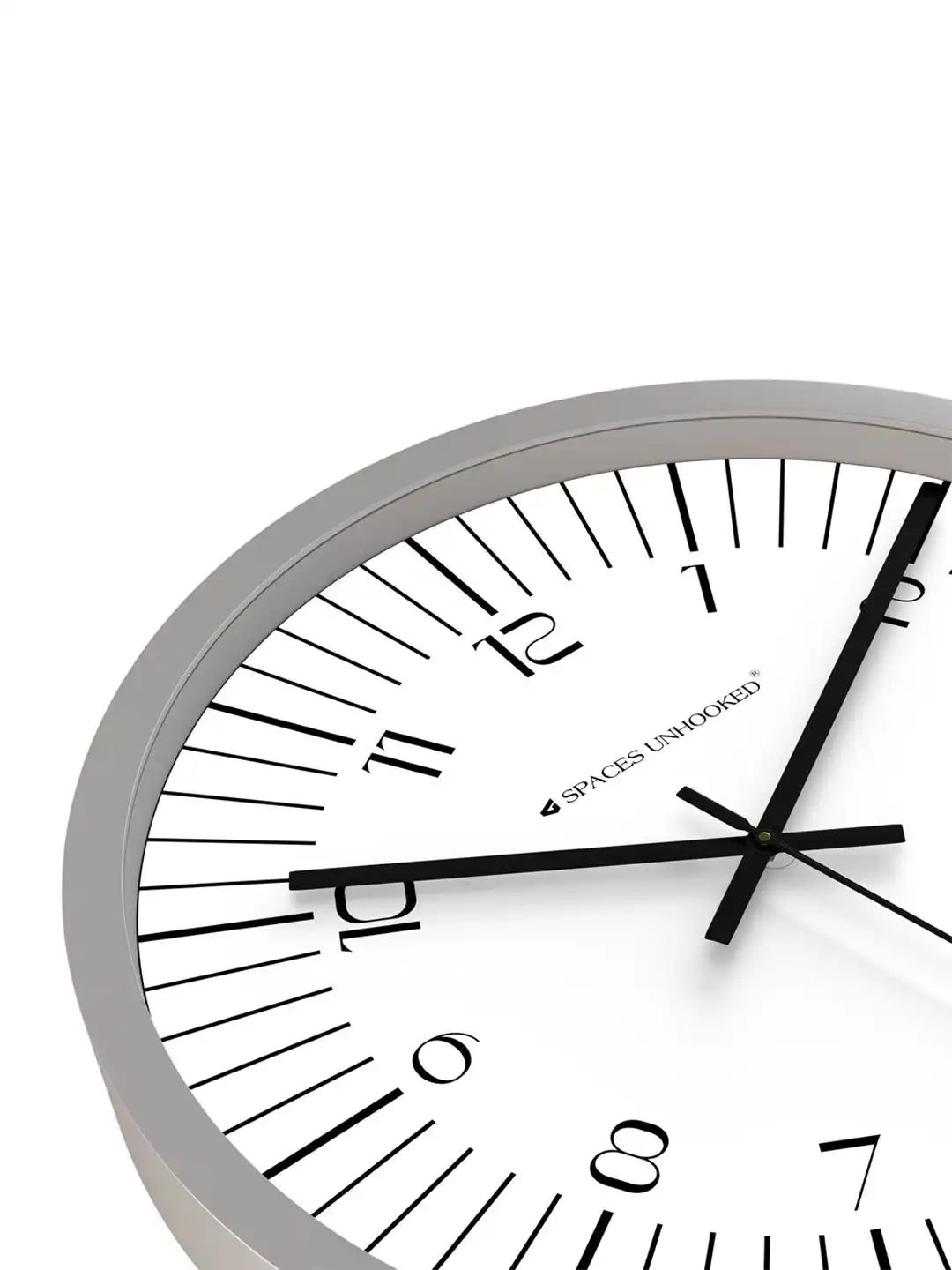Close-up angled front view of Spaces Unhooked grey wall clock with white dial and minimalist Arabic numerals