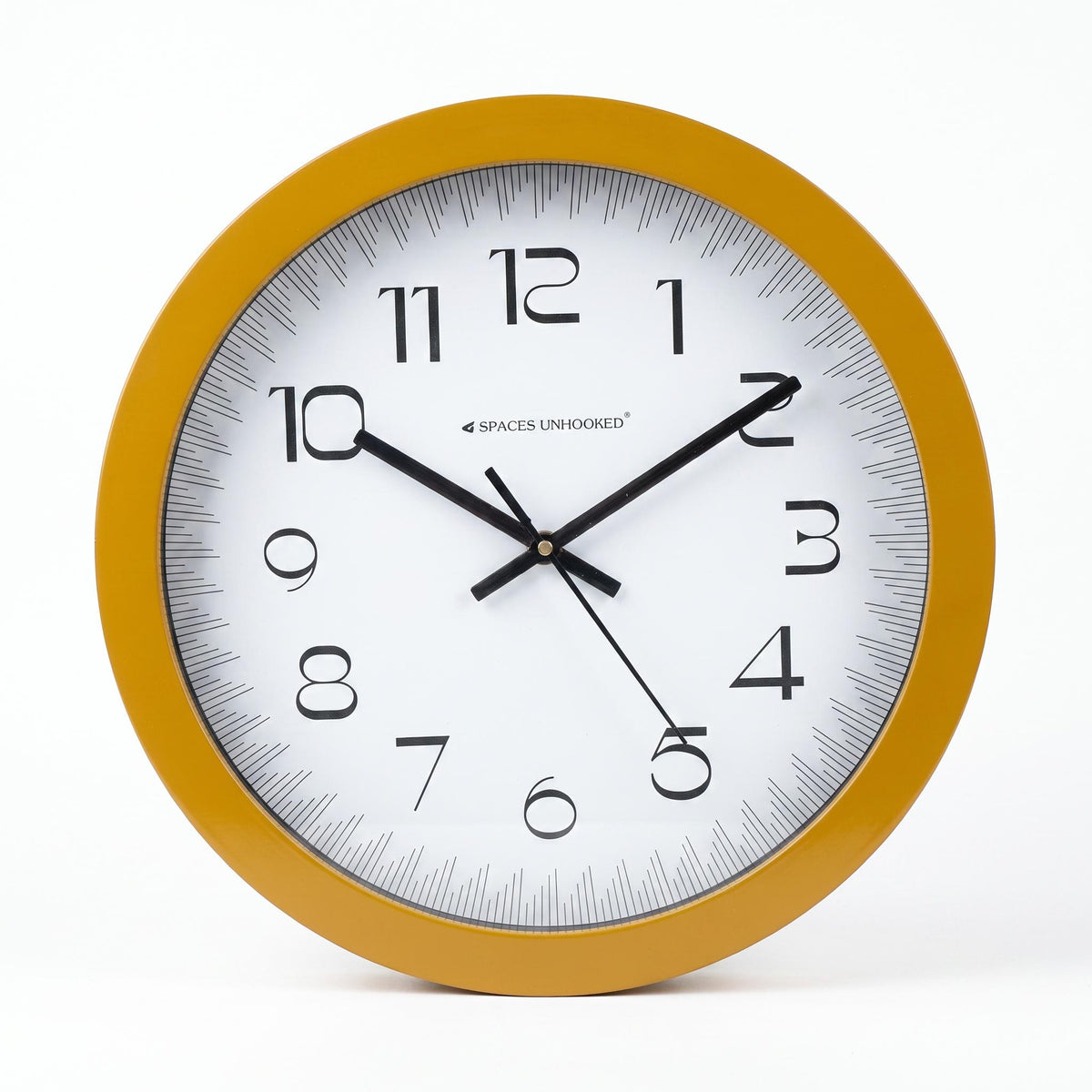 Mustard yellow round wall clock in a kitchen with white walls and light wood shelves