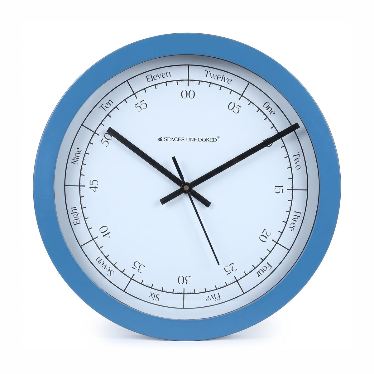 Blue round wall clock in a study with a wooden desk, bookshelf, books and a brass lamp