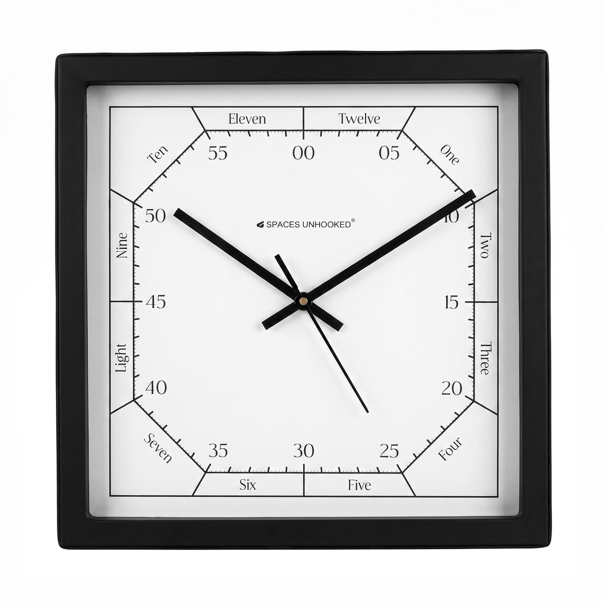 Black and white square wall clock above a desk in a calm home study