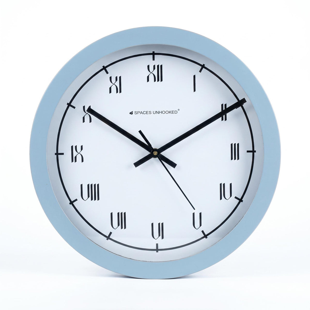 Powder blue round wall clock in a nursery with white furniture, soft toys and pale wood
