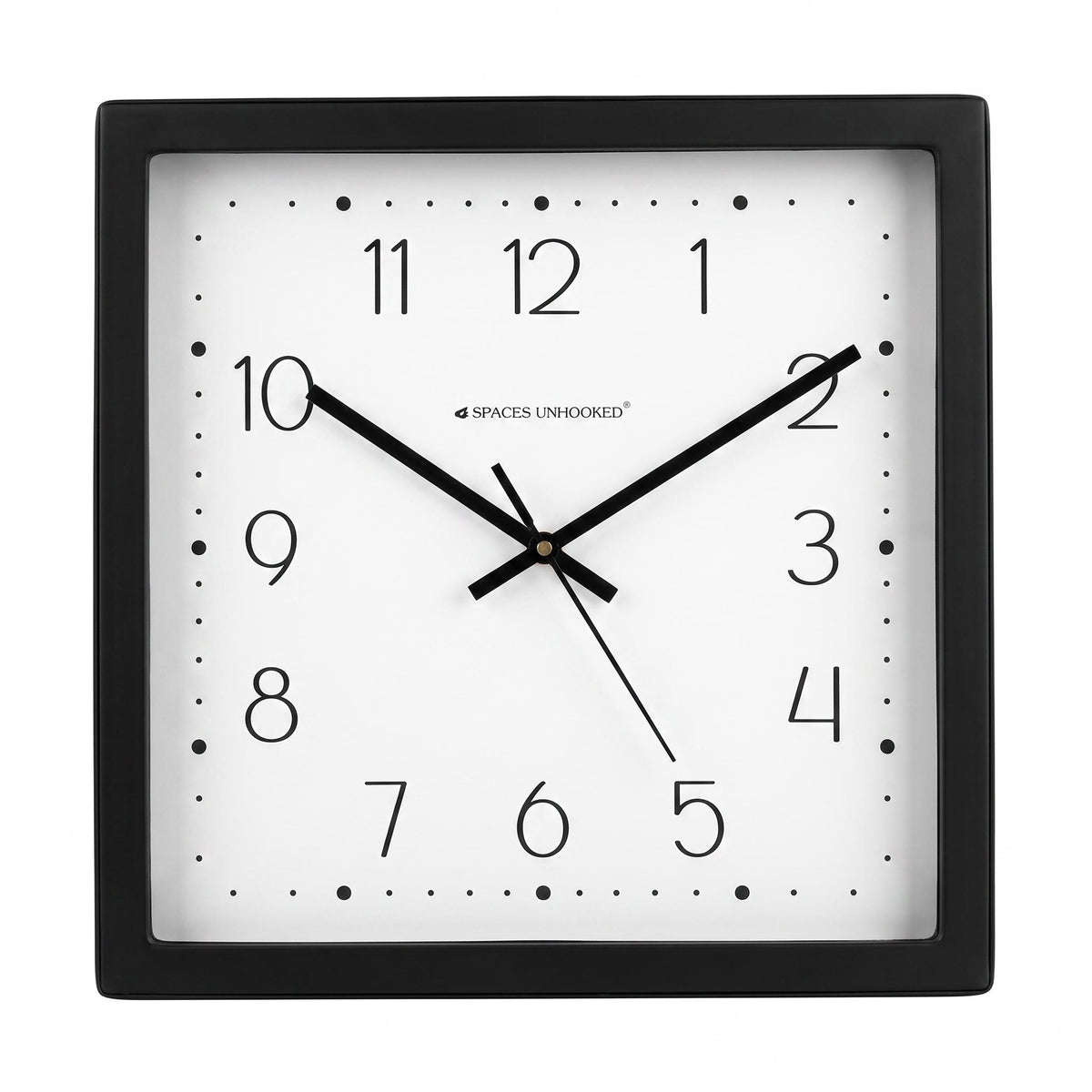Black and white dotted wall clock on a wall above a study desk