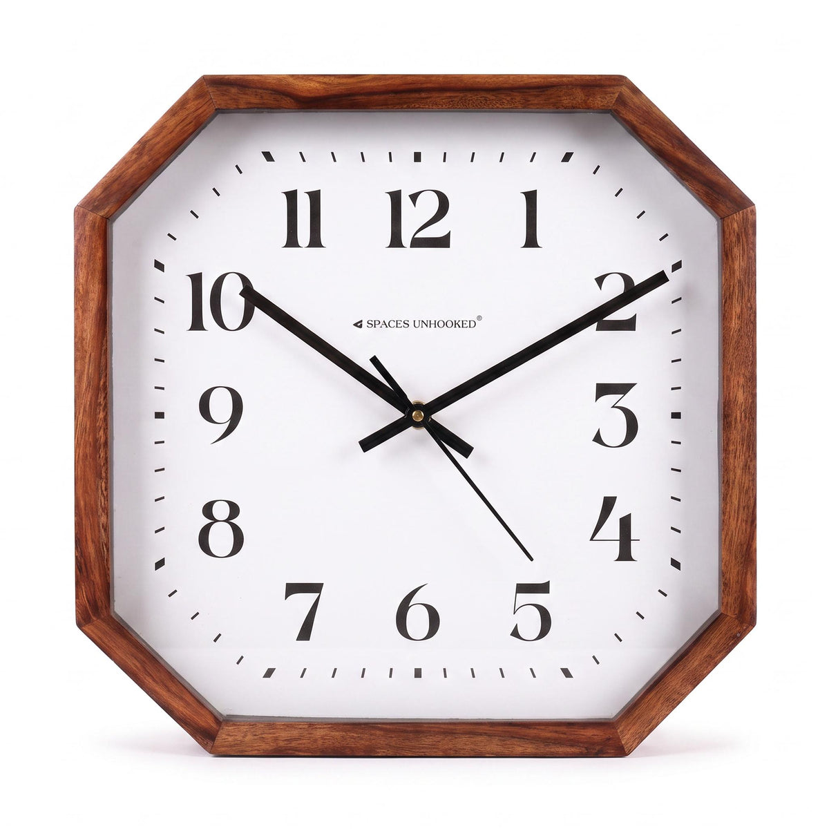 Classic octagonal brown wall clock with white dial on a plain wall in a tidy home office