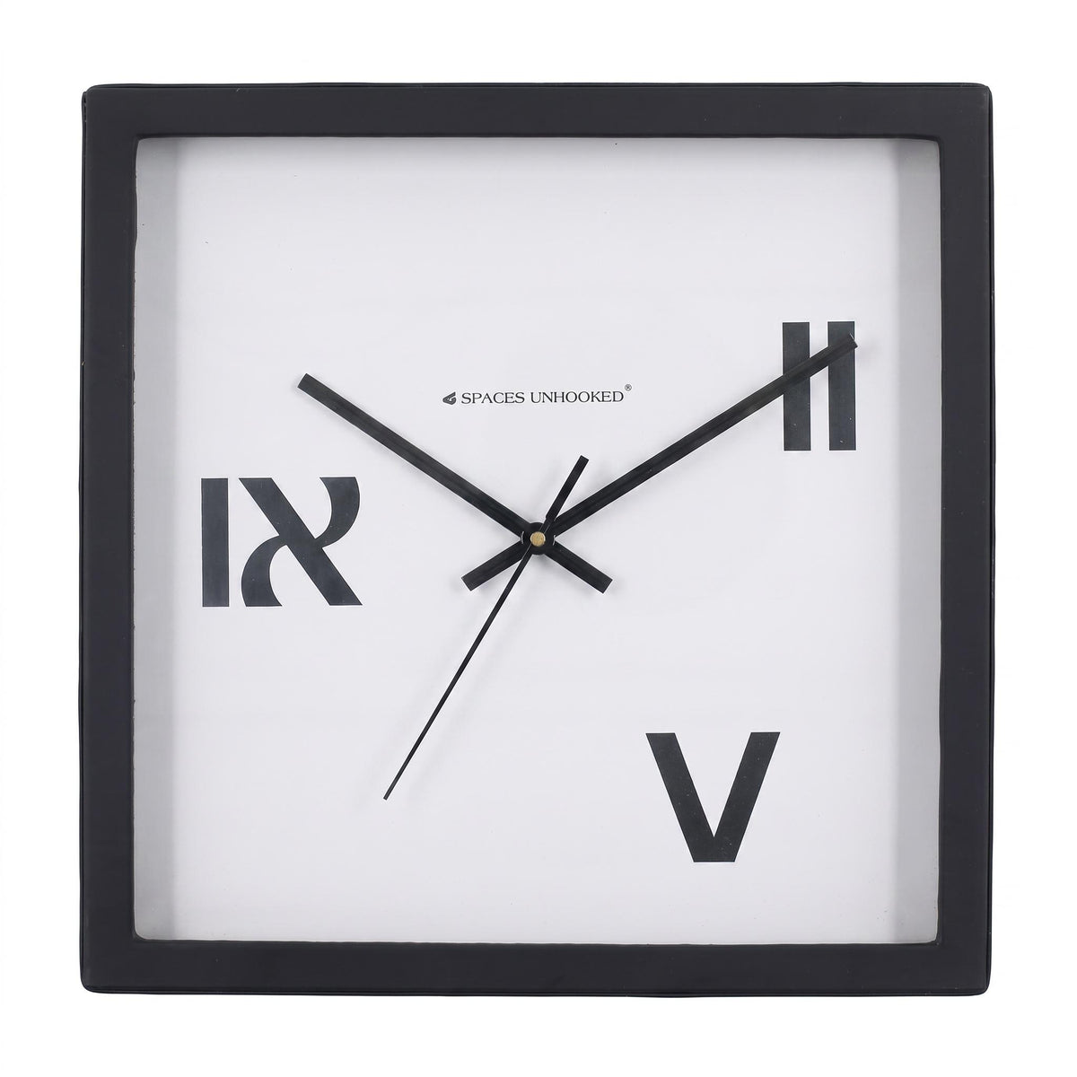 Three roman numeral wall clock on a desk in a creative home office
