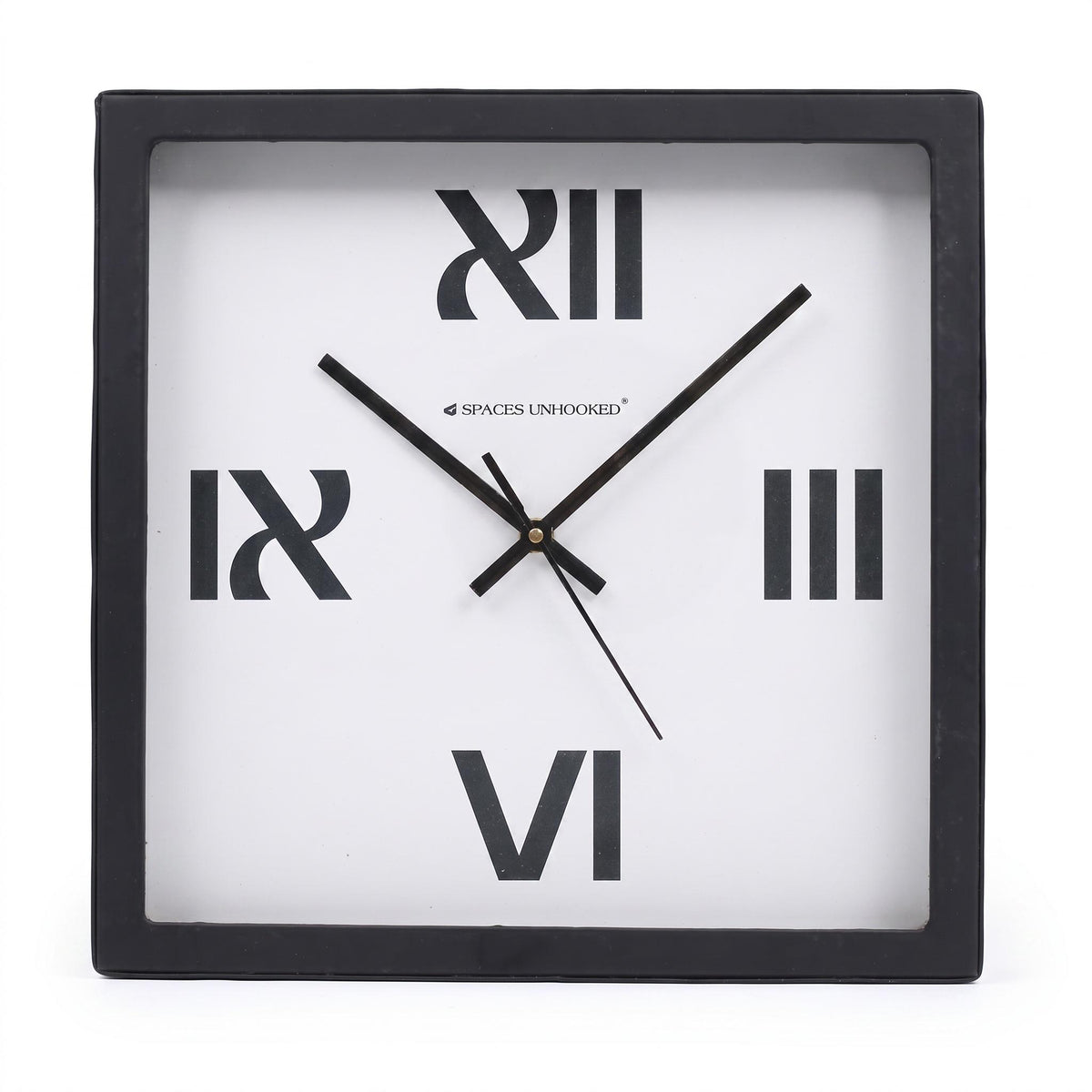 Bold roman numeral wall clock on a desk in a minimal home office