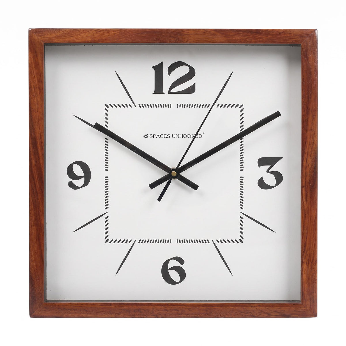 Square wall clock with minimal 12-3-6-9 dial hanging in a calm home office beside a desk