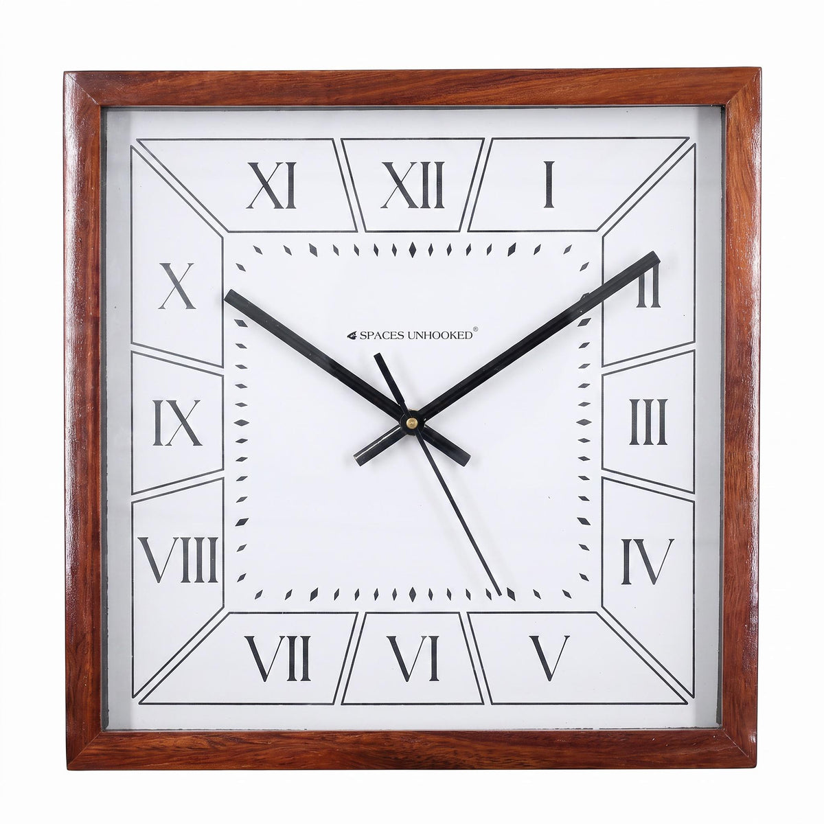 Square wooden wall clock with Roman numerals on a quiet study wall beside a tall bookshelf