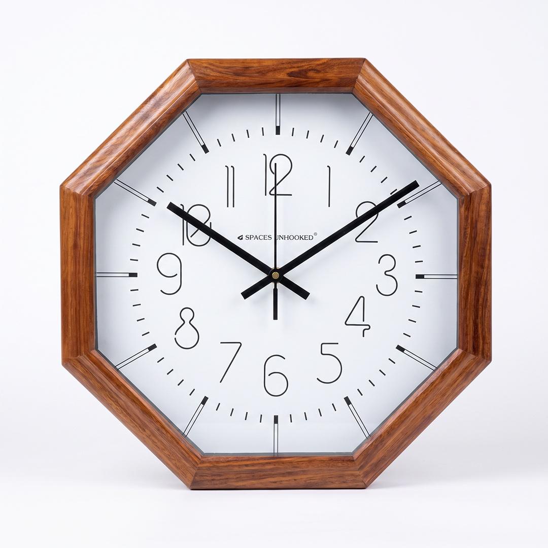 Line numerals octagon wall clock on a bedroom wall above a dresser
