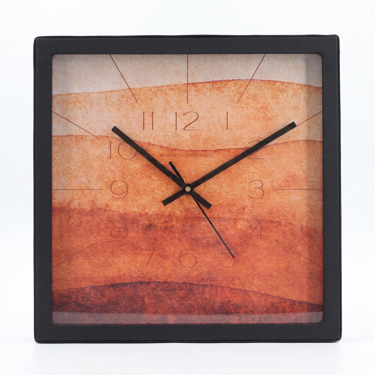 Terracotta watercolour wall clock on a study wall above a wooden desk