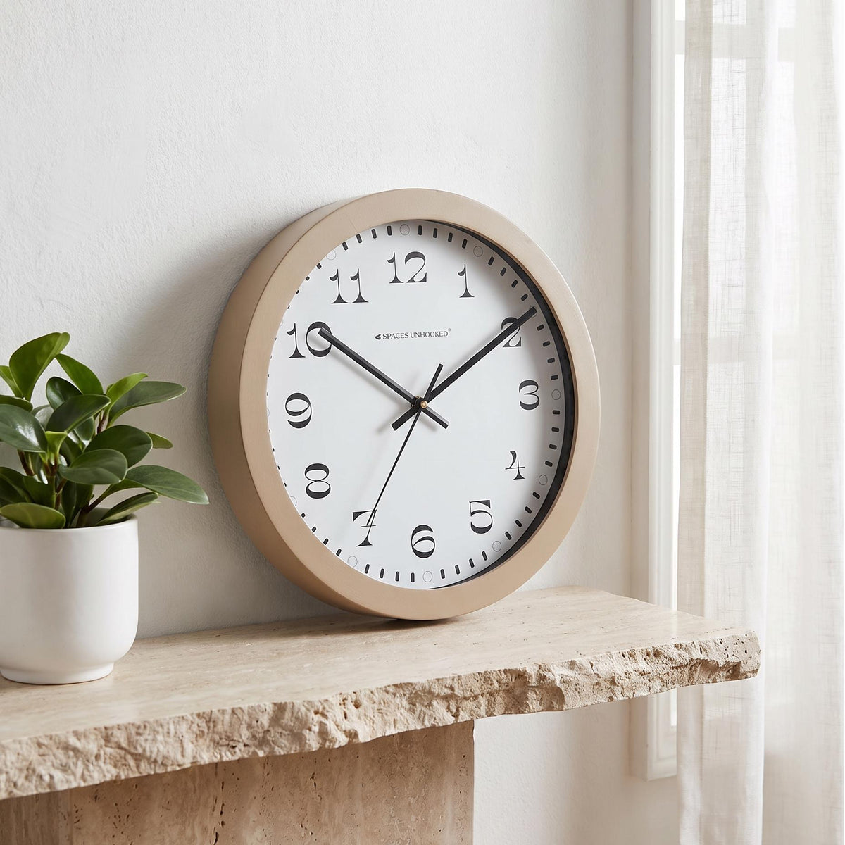 Spaces Unhooked taupe round wall clock with ornate serif numerals on a white dial, front view
