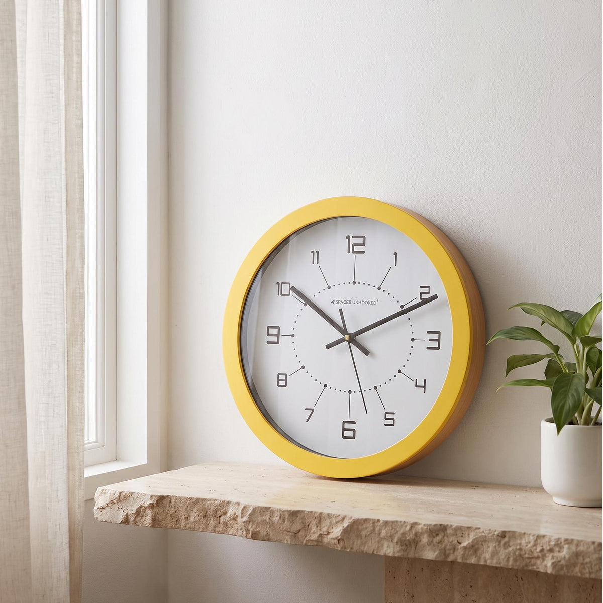 Spaces Unhooked sunshine yellow round wall clock with geometric numerals, front view