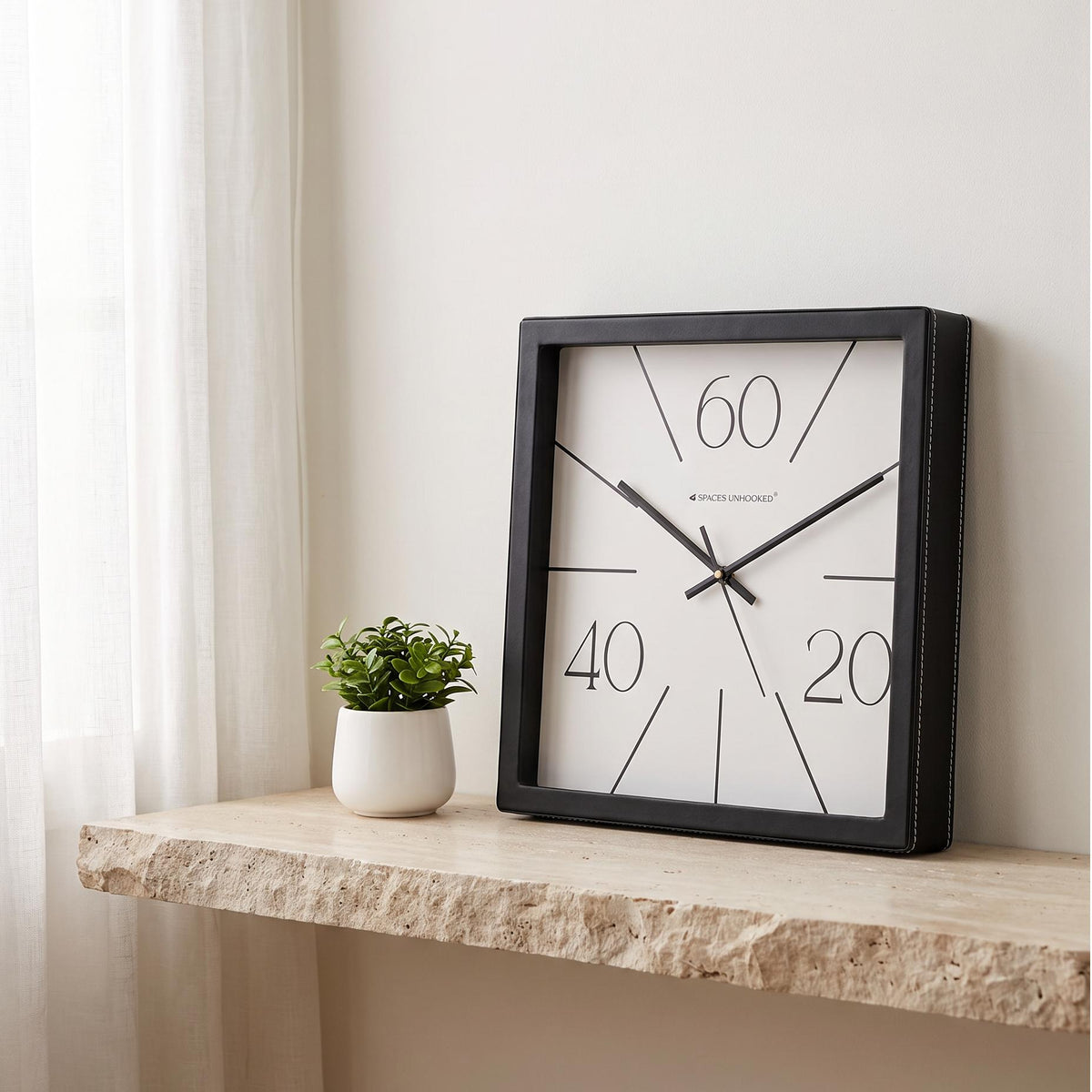 Square black wall clock with radial lines and numerals 20, 40, 60, front view
