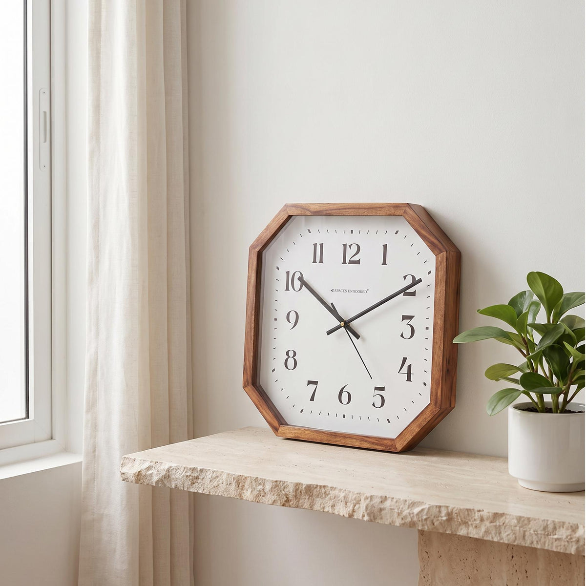Spaces Unhooked octagonal wooden wall clock with bold black numerals on a white dial, front view