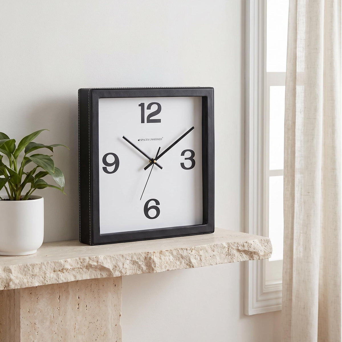 Square black wall clock with bold 12, 3, 6 and 9 numerals on white dial, front view