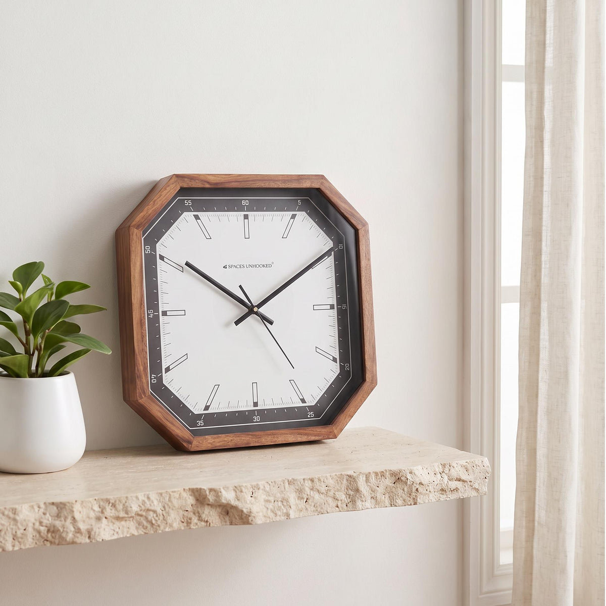 Spaces Unhooked octagonal wooden wall clock with black bezel and white dial, front view