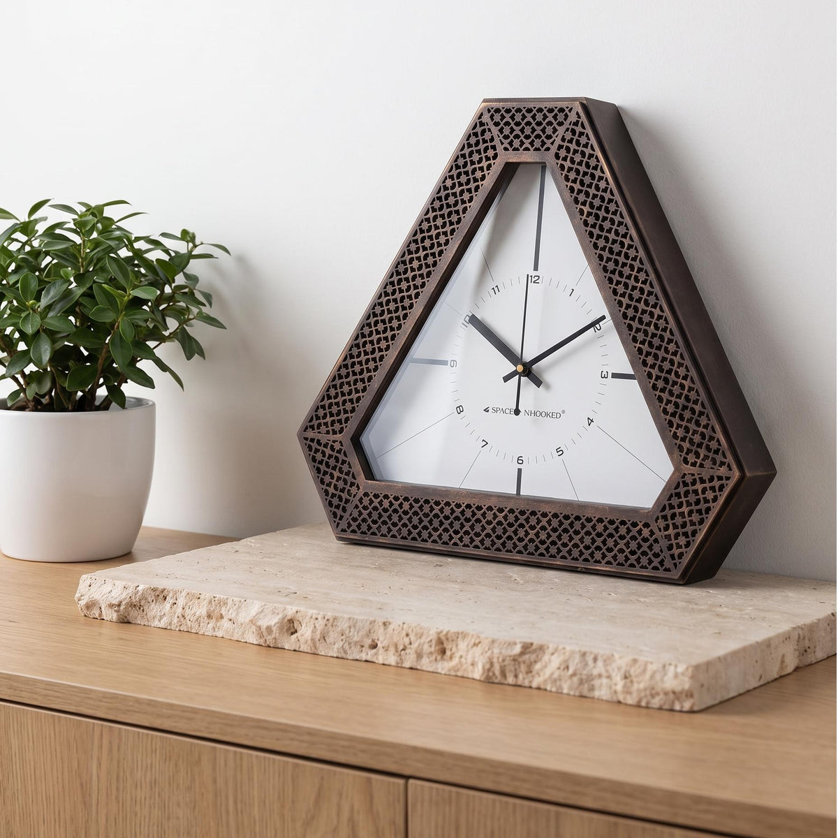 Triangular wall clock with bronze lattice frame and bold hour bars on white dial