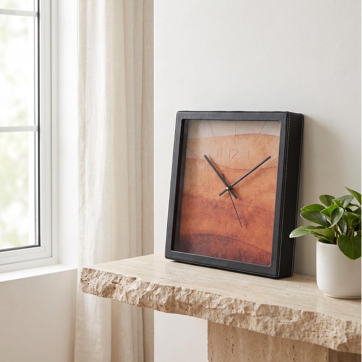 Square black wall clock with terracotta and amber watercolour dial, front view
