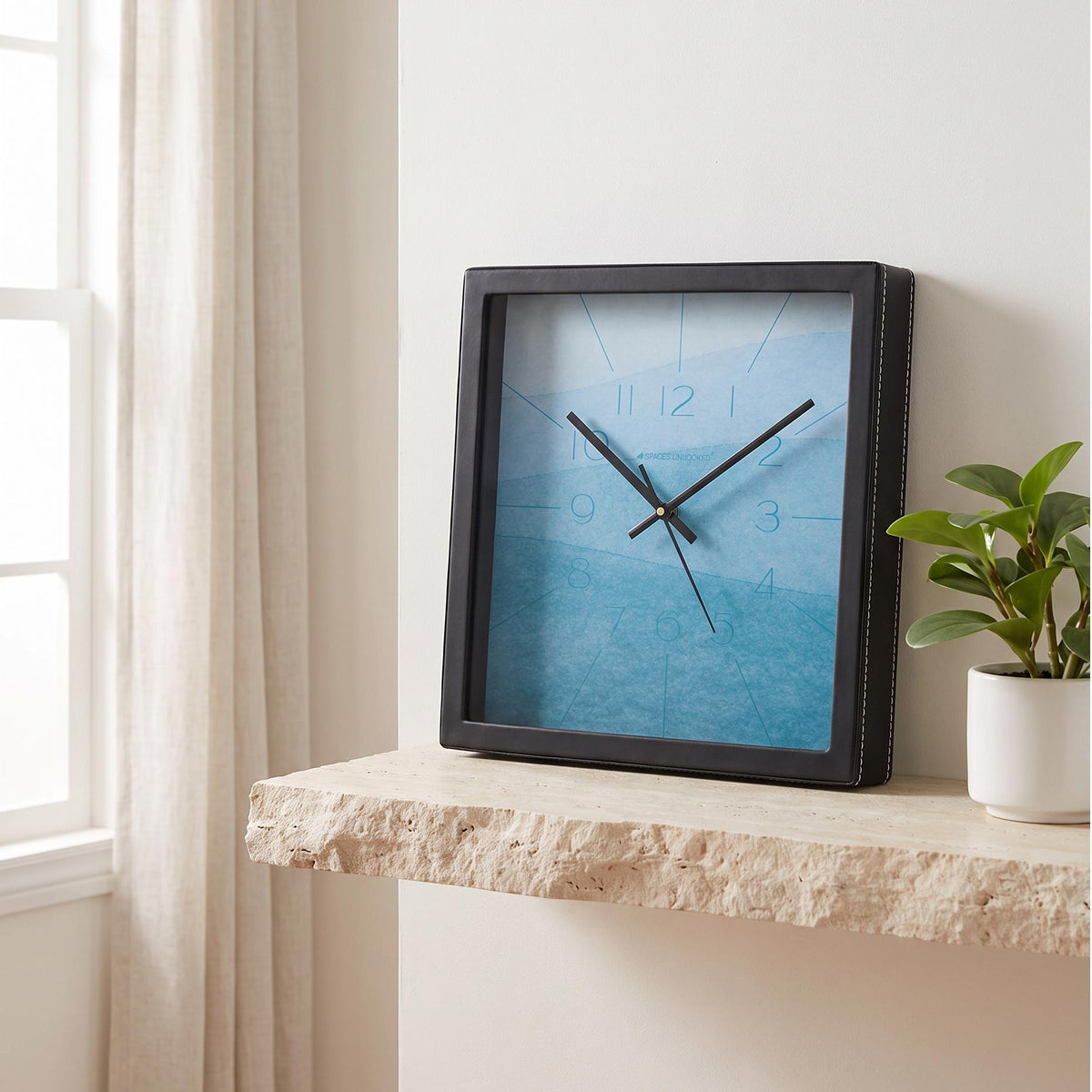 Square black wall clock with sky blue and aqua watercolour dial, front view