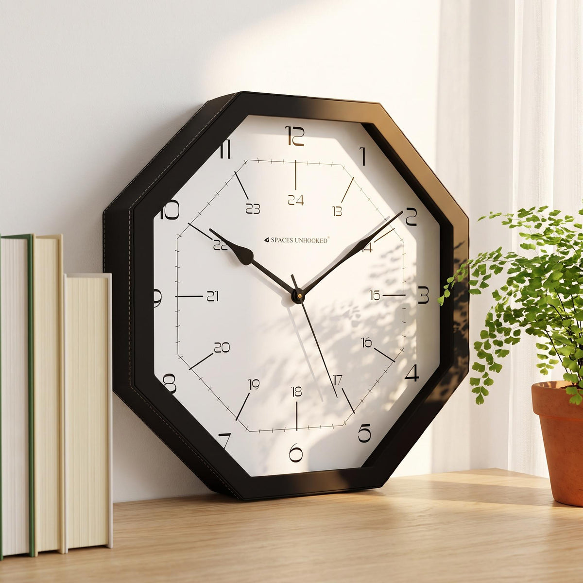 Octagonal black wall clock with 12-hour and 24-hour dial, front view