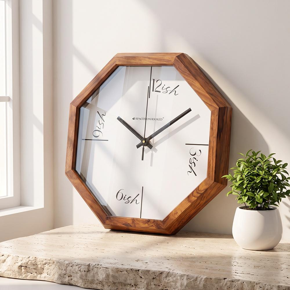 Octagonal wooden wall clock with 12ish, 3ish, 6ish and 9ish script on a white dial
