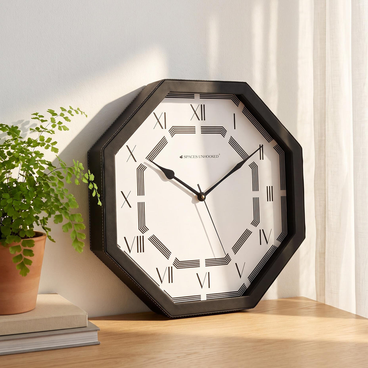 Octagonal black wall clock with Roman numerals and line pattern, front view