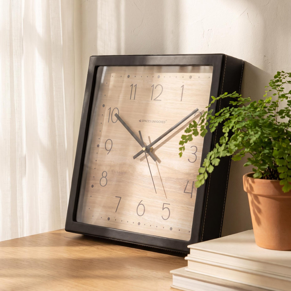 Square black wall clock with wood-grain dial, dotted border and slim numerals, front view