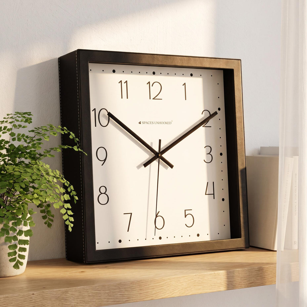 Square black wall clock on a kitchen wall in a bright family home