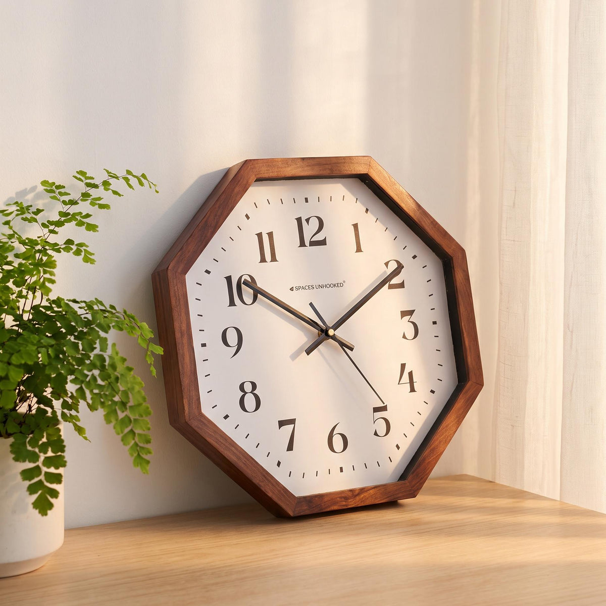 Spaces Unhooked octagonal wooden wall clock with bold black numerals on a white dial, front view