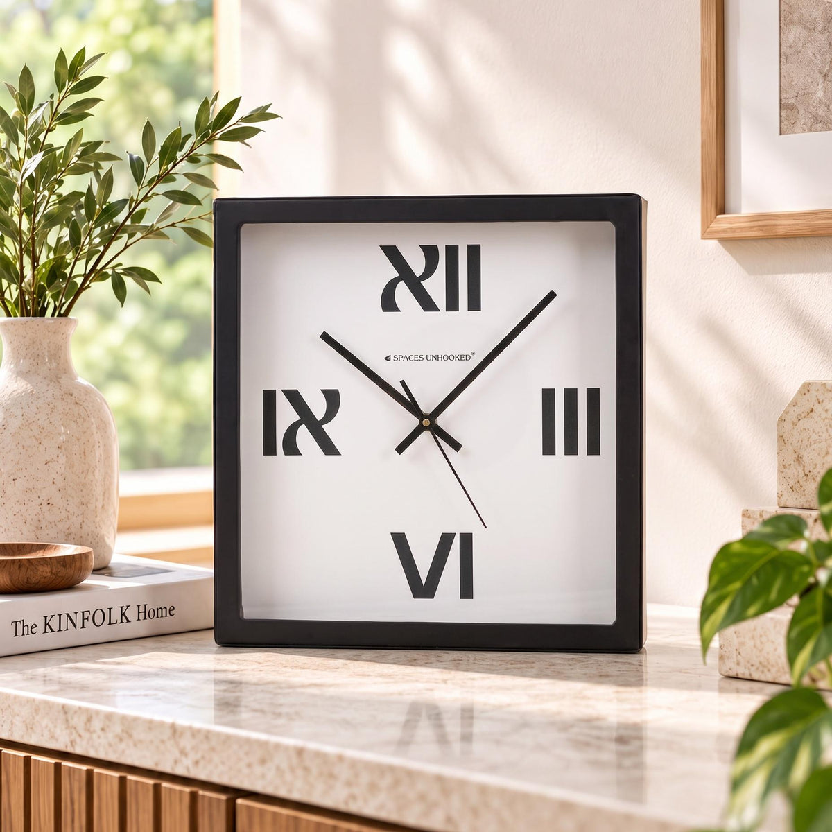 Bold roman numeral wall clock on a hallway above a console table