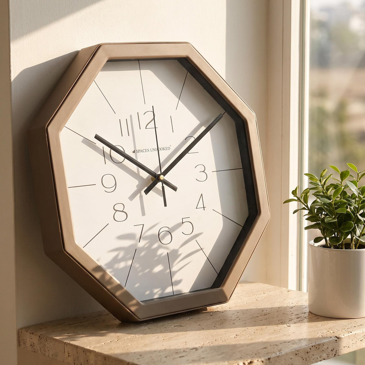 Spaces Unhooked taupe octagonal wall clock with slim numerals on a white dial, front view