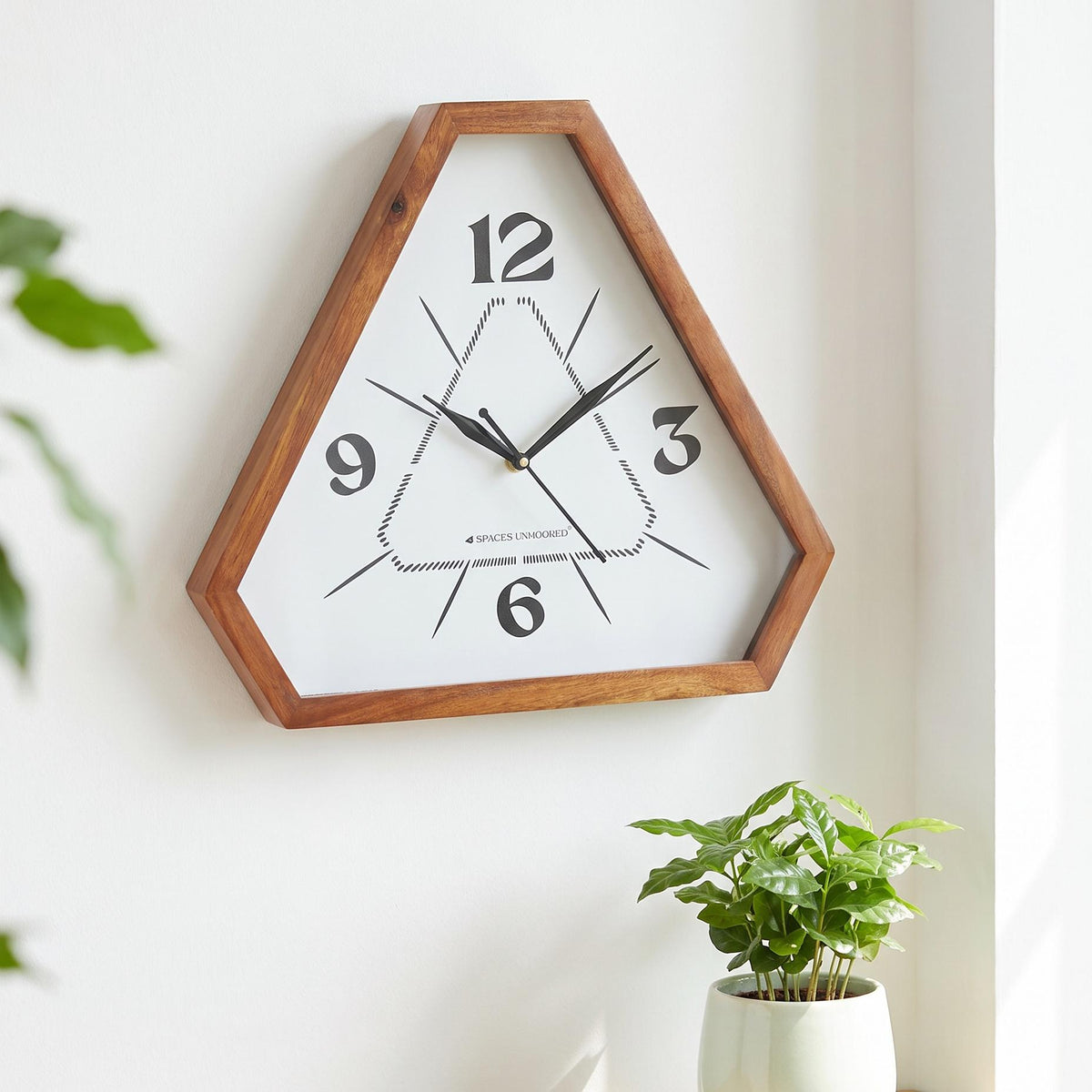 Spaces Unhooked triangular wooden wall clock with dotted inner triangle dial, front view