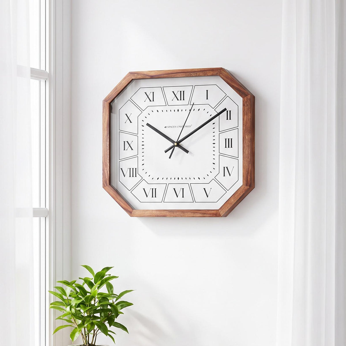 Roman numeral wall clock with brown cut-corner frame on a hallway wall with brass accents