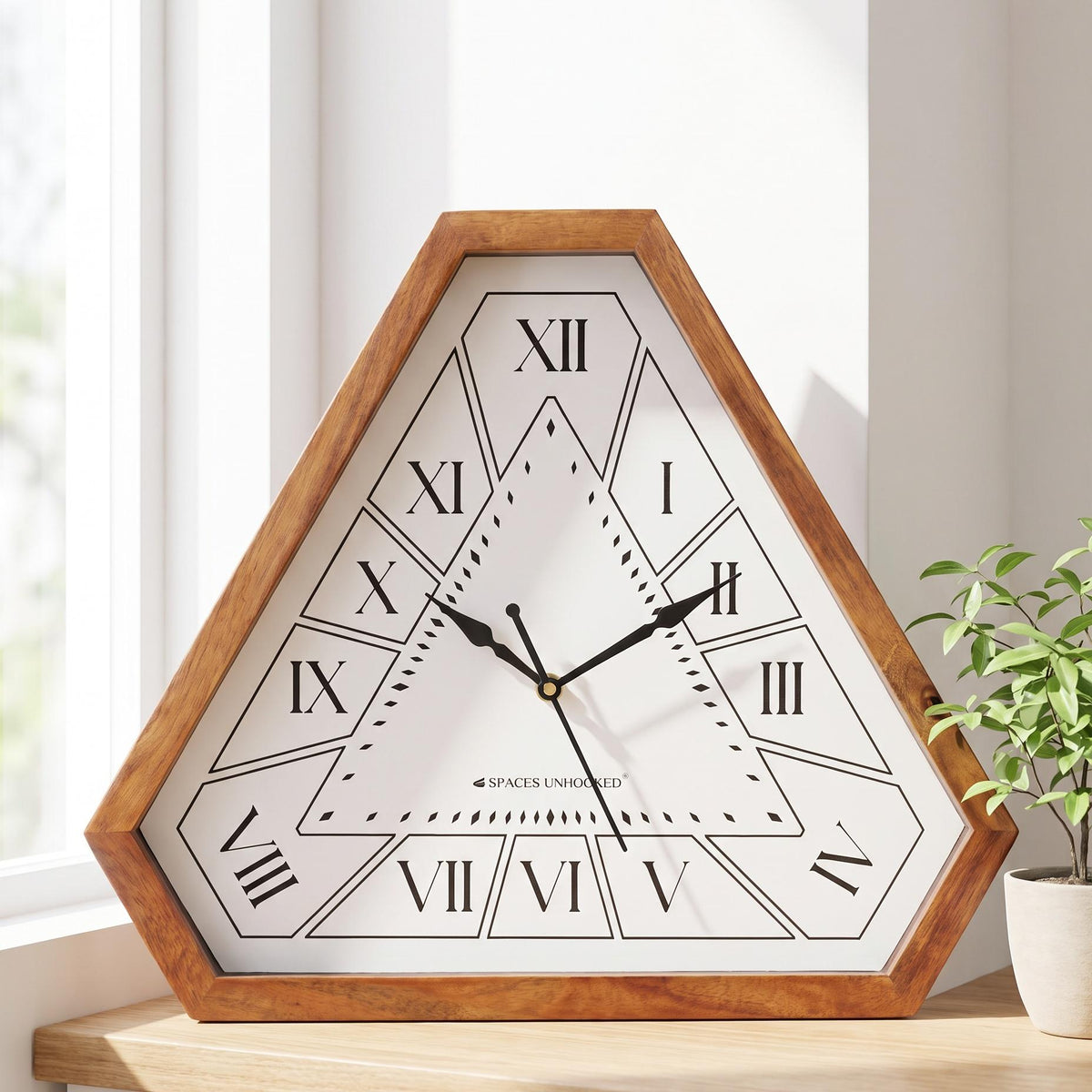 Spaces Unhooked Roman numeral triangular wooden wall clock with white dial, front view