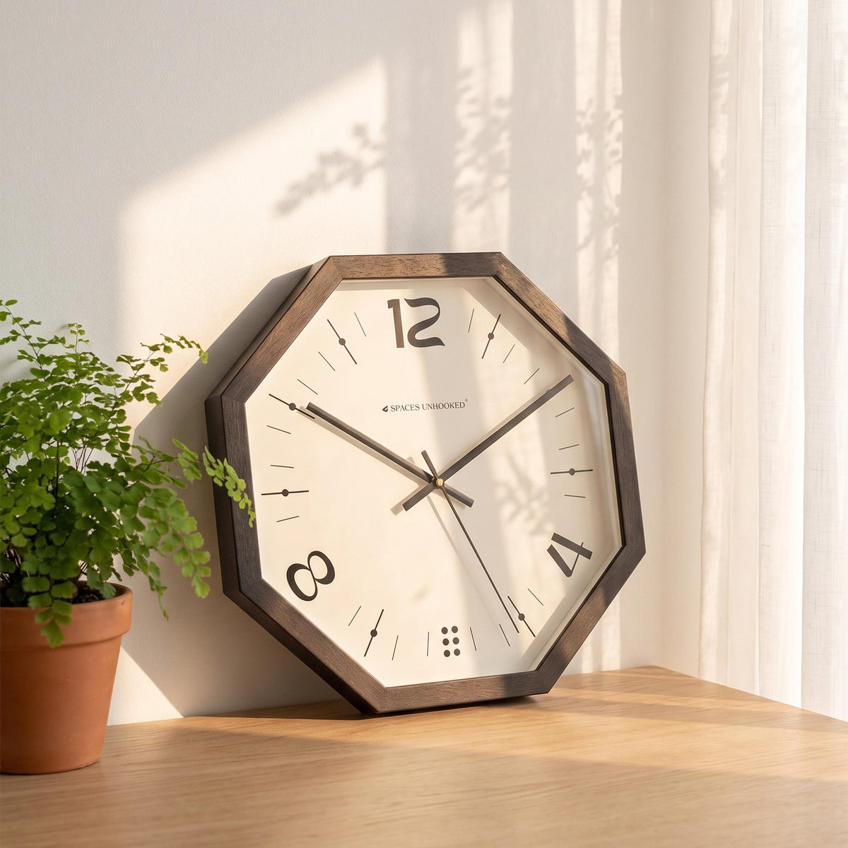 Spaces Unhooked black octagonal wall clock with 12, 4 and 8 numerals, front view