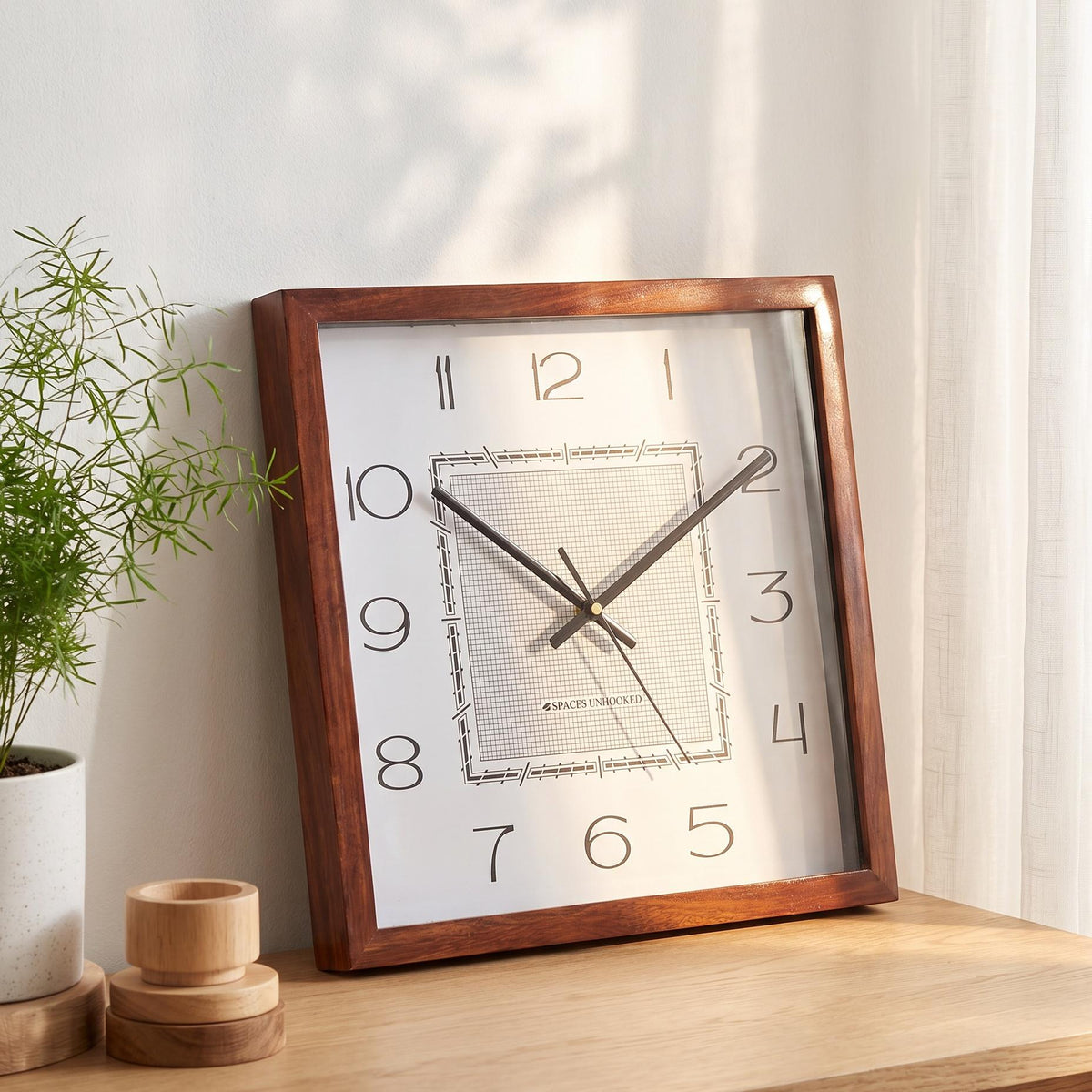 Art deco wooden wall clock above a writing desk in a creative studio or home office