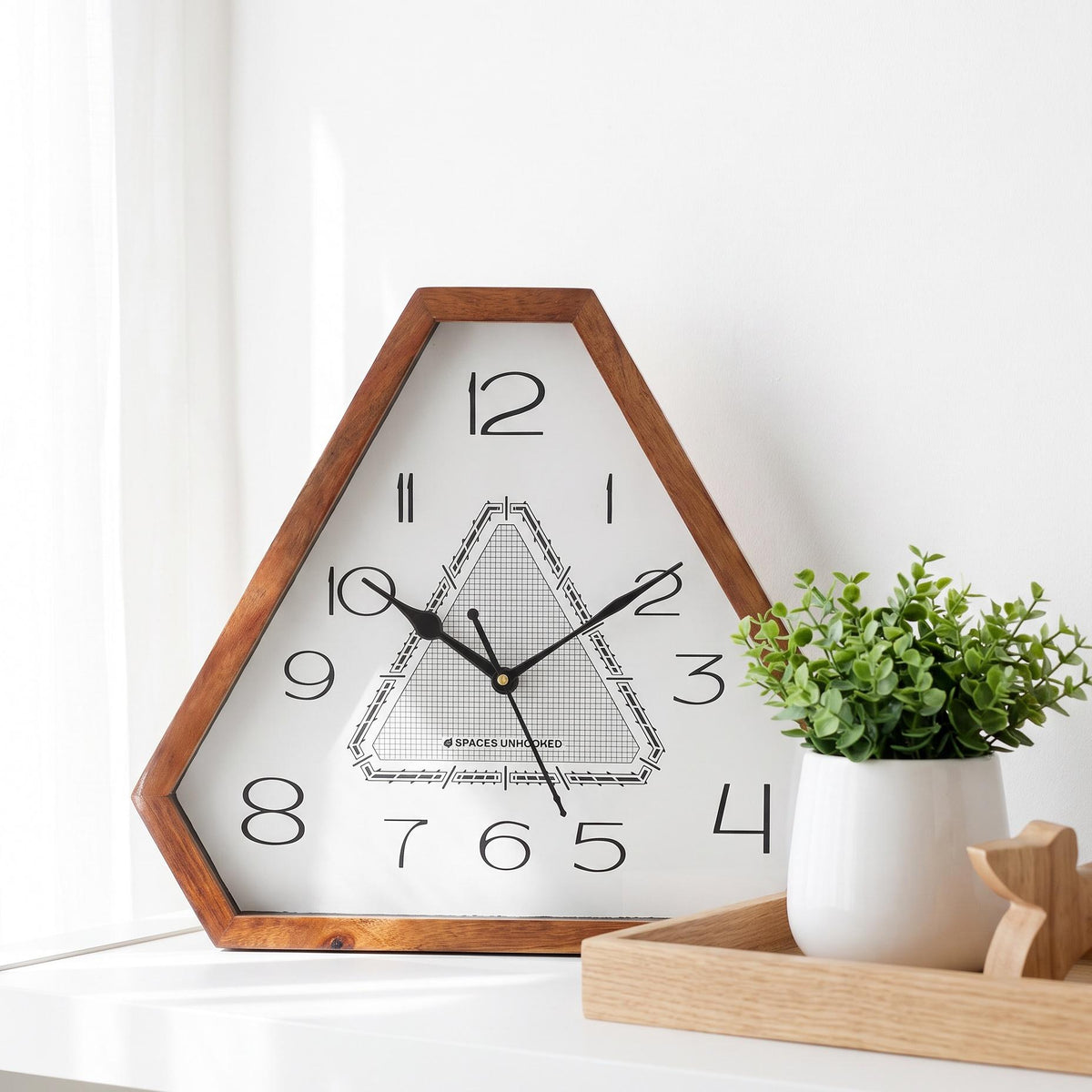 Spaces Unhooked art deco triangular wooden wall clock with fine grid dial, front view