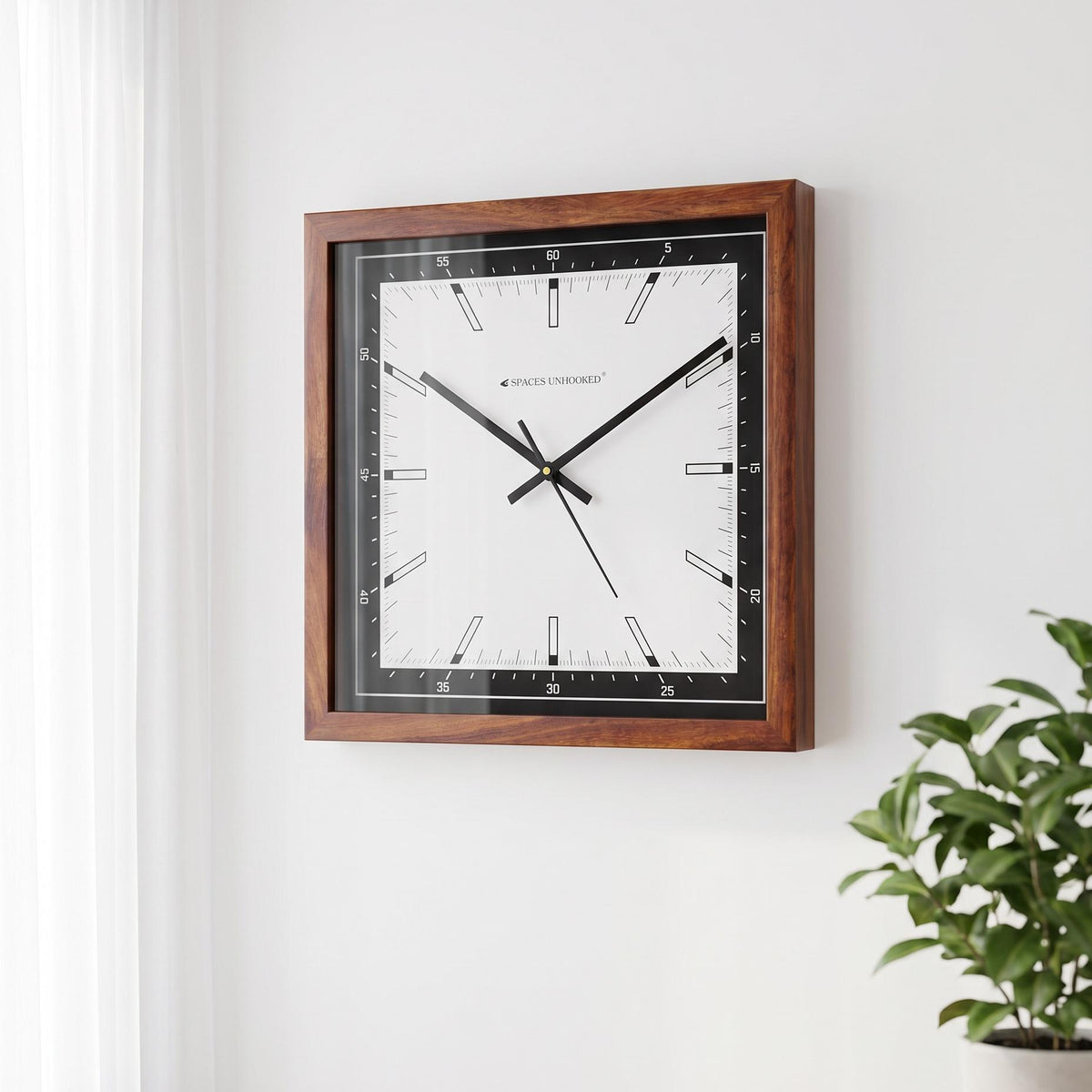 Black bezel wooden wall clock in a bright studio apartment beside light wood furniture